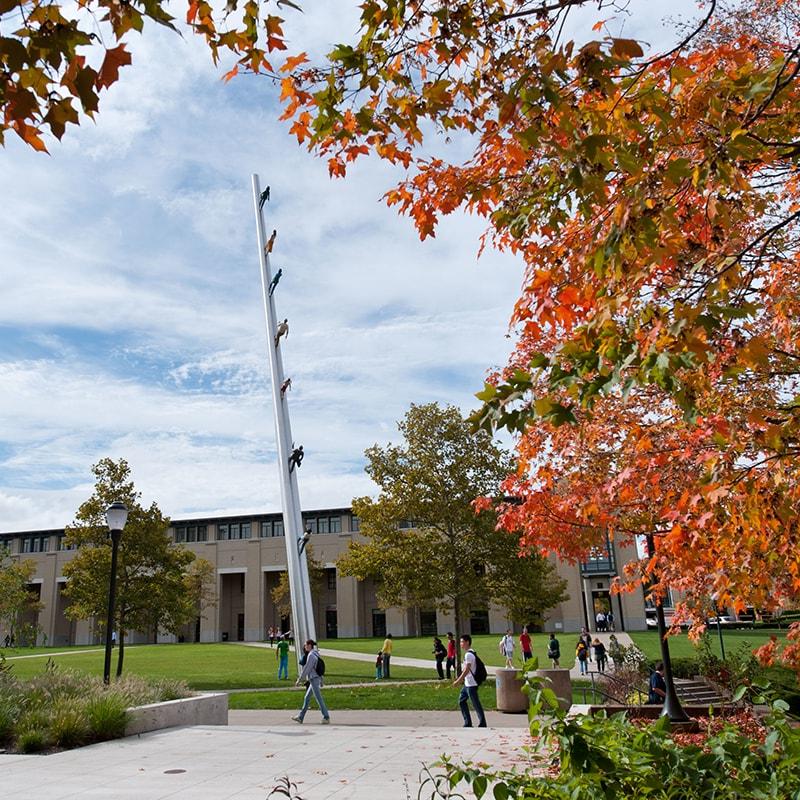 Photo of campus and students walking on a fall day